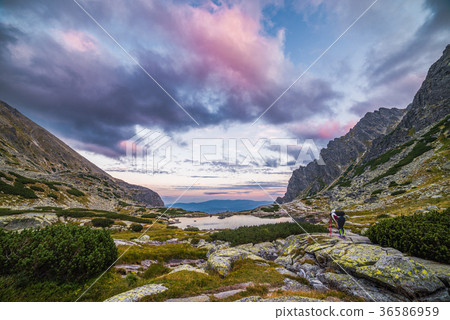 Tourist Takes Picture of Mountain Landscape with a Tarn 36586959