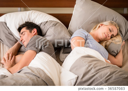 Young man and woman sleeping back-to-back Young man and woman sleeping back-to-back 36587083