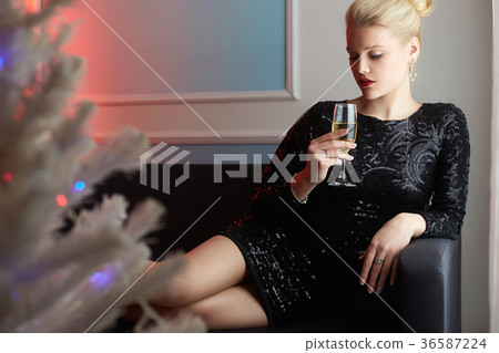 beautiful young woman drinking champagne at home beautiful young woman drinking champagne at home 36587224