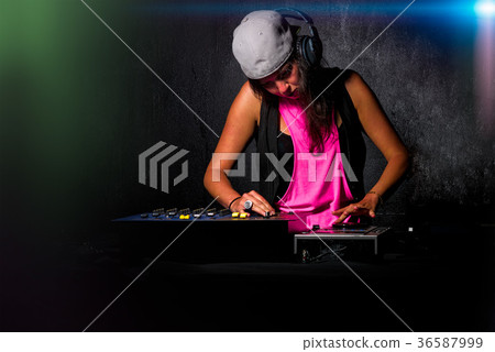 Glamorous girl deejay at work mixing sound on her console at a p 36587999