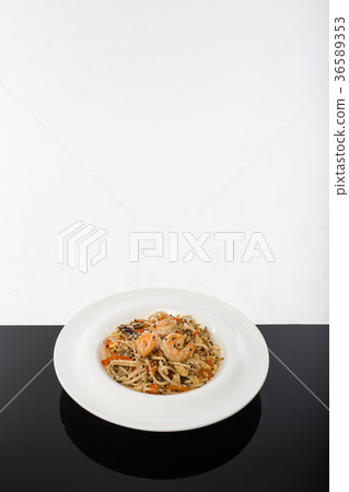 Noodles with seafood on a black table with a white Noodles with seafood on a black table with a white 36589353