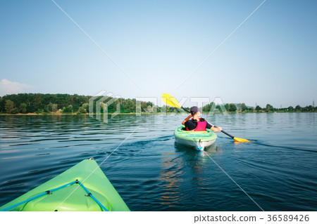 Boy in life jacket on green kayak Boy in life jacket on green kayak 36589426