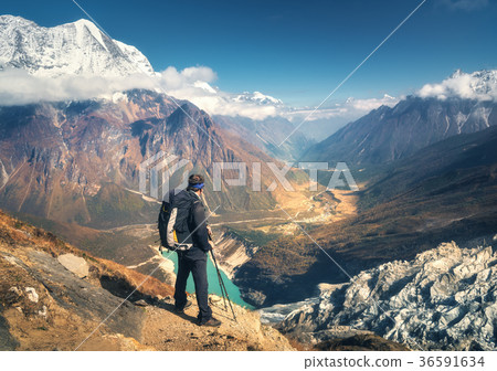 Standing sporty man with backpack on the mountain peak 36591634