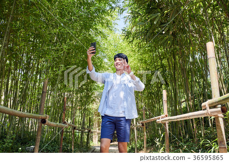 Young guy take a relax in park, sit on green grass and walking in around. 030 Young guy take a relax in park, sit on green grass and walking in around. 030 36595865