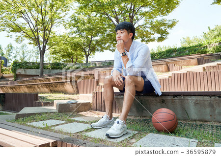 Young guy take a relax in park, sit on green grass and walking in around. 037 36595879
