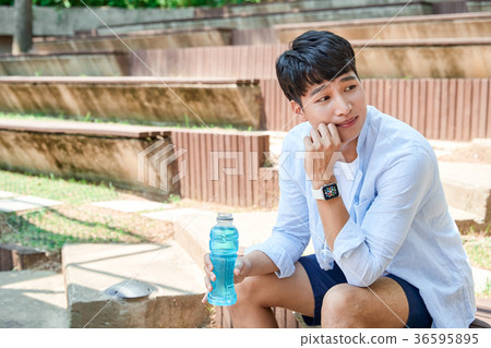 Young guy take a relax in park, sit on green grass and walking in around. 044 Young guy take a relax in park, sit on green grass and walking in around. 044 36595895