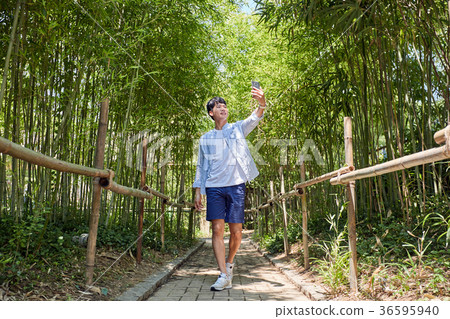 Young guy take a relax in park, sit on green grass and walking in around. 024 Young guy take a relax in park, sit on green grass and walking in around. 024 36595940