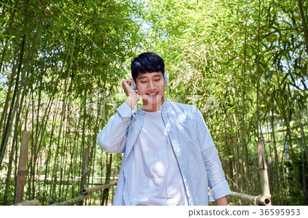 Young guy take a relax in park, sit on green grass and walking in around. 029 Young guy take a relax in park, sit on green grass and walking in around. 029 36595953