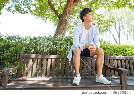 Young guy take a relax in park, sit on green grass and walking in around. 055 Young guy take a relax in park, sit on green grass and walking in around. 055 36595963