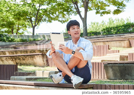 Young guy take a relax in park, sit on green grass and walking in around. 045 Young guy take a relax in park, sit on green grass and walking in around. 045 36595965