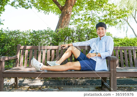 Young guy take a relax in park, sit on green grass and walking in around. 057 Young guy take a relax in park, sit on green grass and walking in around. 057 36595976
