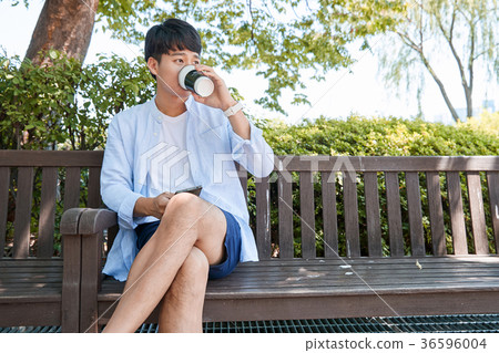 Young guy take a relax in park, sit on green grass and walking in around. 063 Young guy take a relax in park, sit on green grass and walking in around. 063 36596004