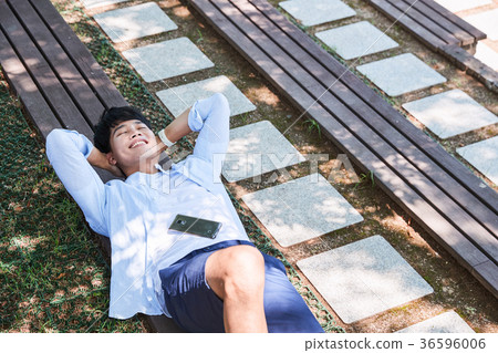 Young guy take a relax in park, sit on green grass and walking in around. 059 Young guy take a relax in park, sit on green grass and walking in around. 059 36596006