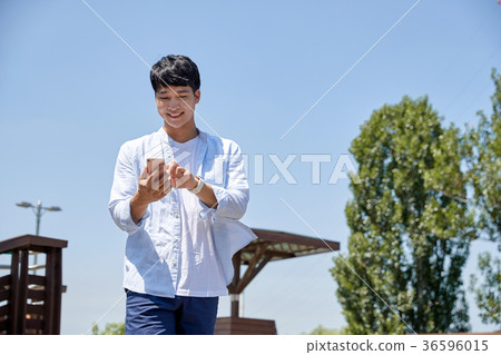 Young guy take a relax in park, sit on green grass and walking in around. 010 Young guy take a relax in park, sit on green grass and walking in around. 010 36596015