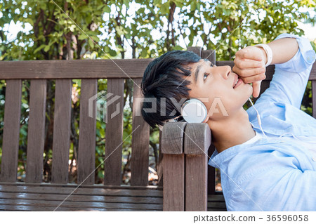 Young guy take a relax in park, sit on green grass and walking in around. 082 Young guy take a relax in park, sit on green grass and walking in around. 082 36596058
