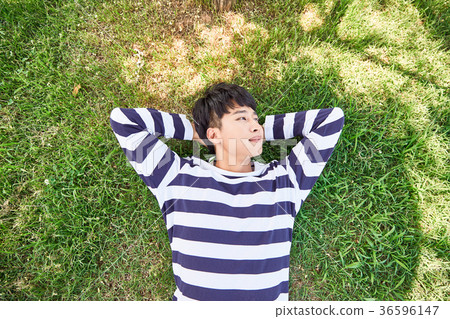 Young guy take a relax in park, sit on green grass and walking in around. 126 Young guy take a relax in park, sit on green grass and walking in around. 126 36596147