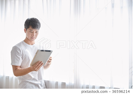 Young guy standing at the front of window with bright sunlight. 159 36596214