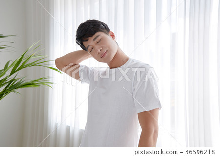 Young guy standing at the front of window with bright sunlight. 152 36596218