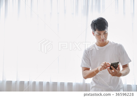 Young guy standing at the front of window with bright sunlight. 161 Young guy standing at the front of window with bright sunlight. 161 36596228