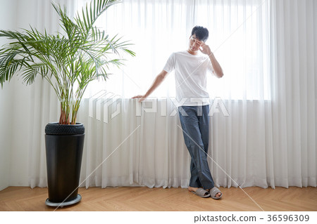 Young guy standing at the front of window with bright sunlight. 175 36596309