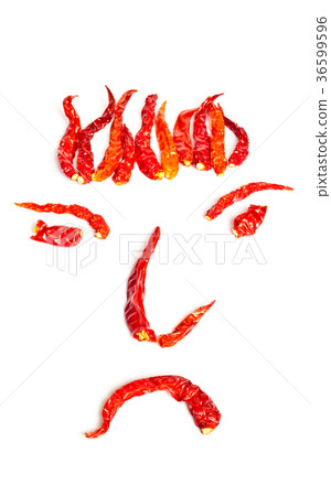 Dried red hot chillies in a Face shape on white 36599596