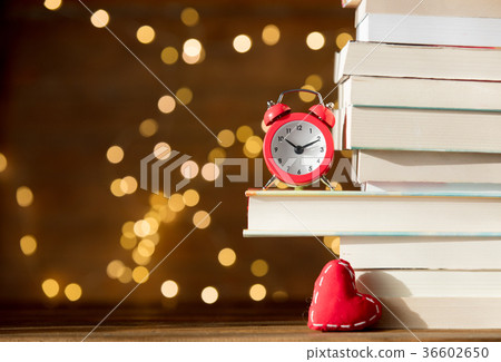 Vintage alarm clock and pile of books Vintage alarm clock and pile of books 36602650