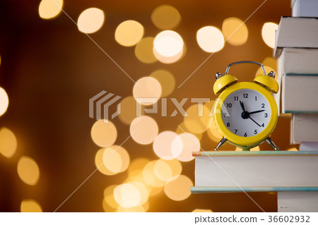 Vintage alarm clock and pile of books Vintage alarm clock and pile of books 36602932