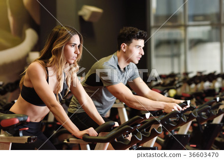 Couple in a spinning class wearing sportswear. Couple in a spinning class wearing sportswear. 36603470