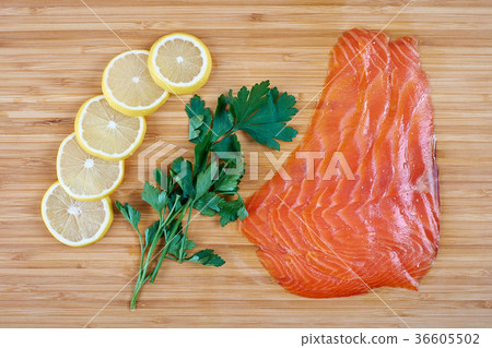 Fillet trout with fresh herbs and lemon on a board 36605502