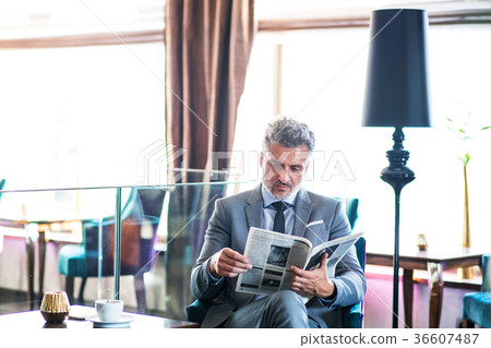 Mature businessman reading newspapers in a hotel 36607487
