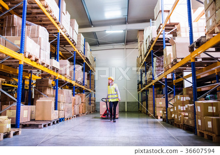 Woman warehouse worker with hand forklift truck. Woman warehouse worker with hand forklift truck. 36607594