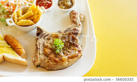 Pork Chop steak on a yellow table. Pork Chop steak on a yellow table. 36608385