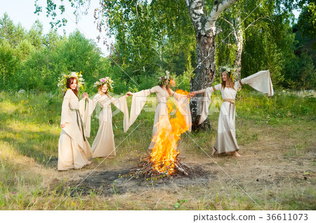 Beautiful women with flower wreath near bonfire Beautiful women with flower wreath near bonfire 36611073