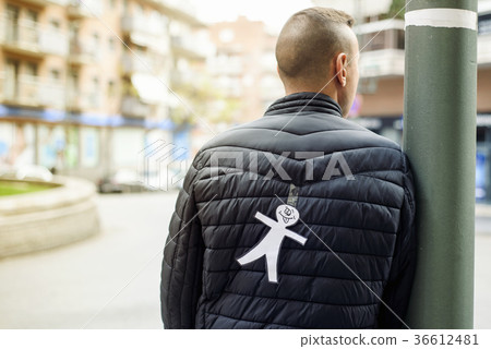 young man with a paper man attached to his back 36612481