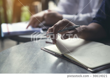 Men are opening book to take note of ideas. 36614021