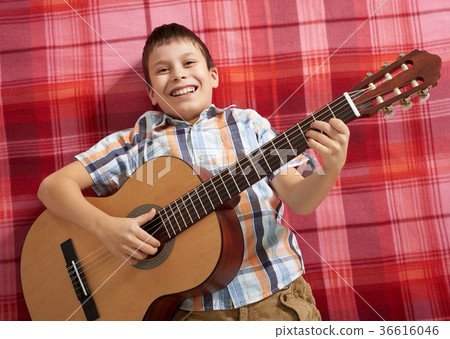 boy playing music on guitar 36616046