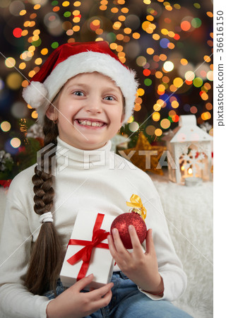 Girl dressed in santa hat with christmas gifts Girl dressed in santa hat with christmas gifts 36616150