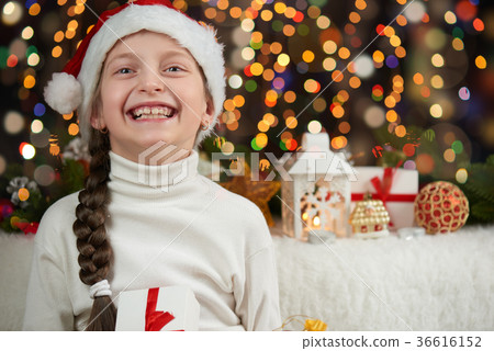 Girl dressed in santa hat with christmas gifts 36616152