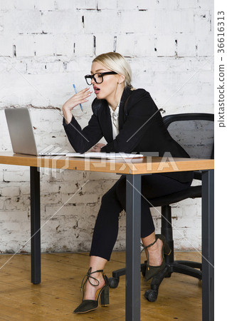 Young blond beauty businesswoman sitting at a Young blond beauty businesswoman sitting at a 36616313