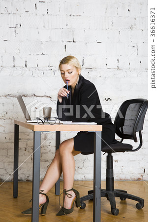Young blond beauty businesswoman sitting at a 36616371