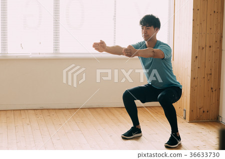 Young Japanese man doing squats 36633730