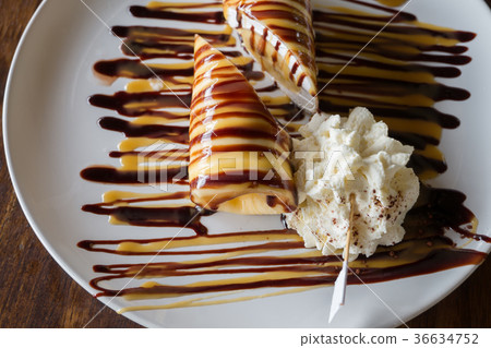 Banana crepe roll with sauce on white plate Banana crepe roll with sauce on white plate 36634752