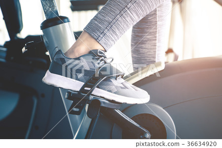 Woman feet cycling on fitness bike machine Woman feet cycling on fitness bike machine 36634920