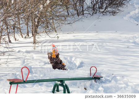 Beautiful little girl playing in a snow 36635009