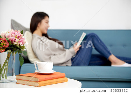 Daily life of a young woman in her 20s lying on the sofa reading a lifestyle Daily life of a young woman in her 20s lying on the sofa reading a lifestyle 36635512