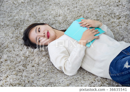 日常生活,生活故事工作,閱讀一名躺在地毯上正在閱讀的年輕女子 日常生活,生活故事工作,閱讀一名躺在地毯上正在閱讀的年輕女子 36635541