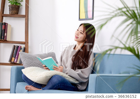 A woman in her 20s reading and relaxing on the couch, Lifestyle 36636152