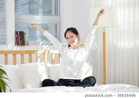 Young woman in twenties stretching in bed. Holiday, lifestyle 36636486