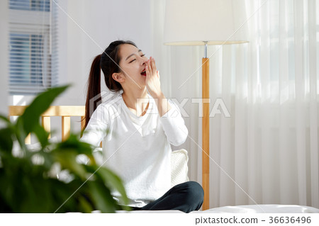 A young woman in her twenties yawning on a bed. Holiday, lifestyle A young woman in her twenties yawning on a bed. Holiday, lifestyle 36636496