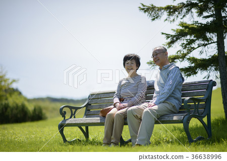 Smiling senior couple sitting on a bench 36638996